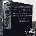 ornate grey gravestone with flowers carved in