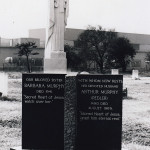 feature granite headstones and white marble Jesus statue